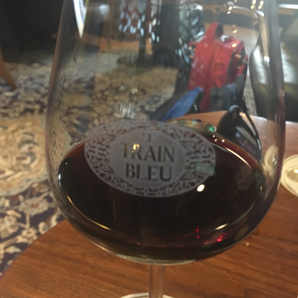 Glass of wine with Le Train Bleu logo